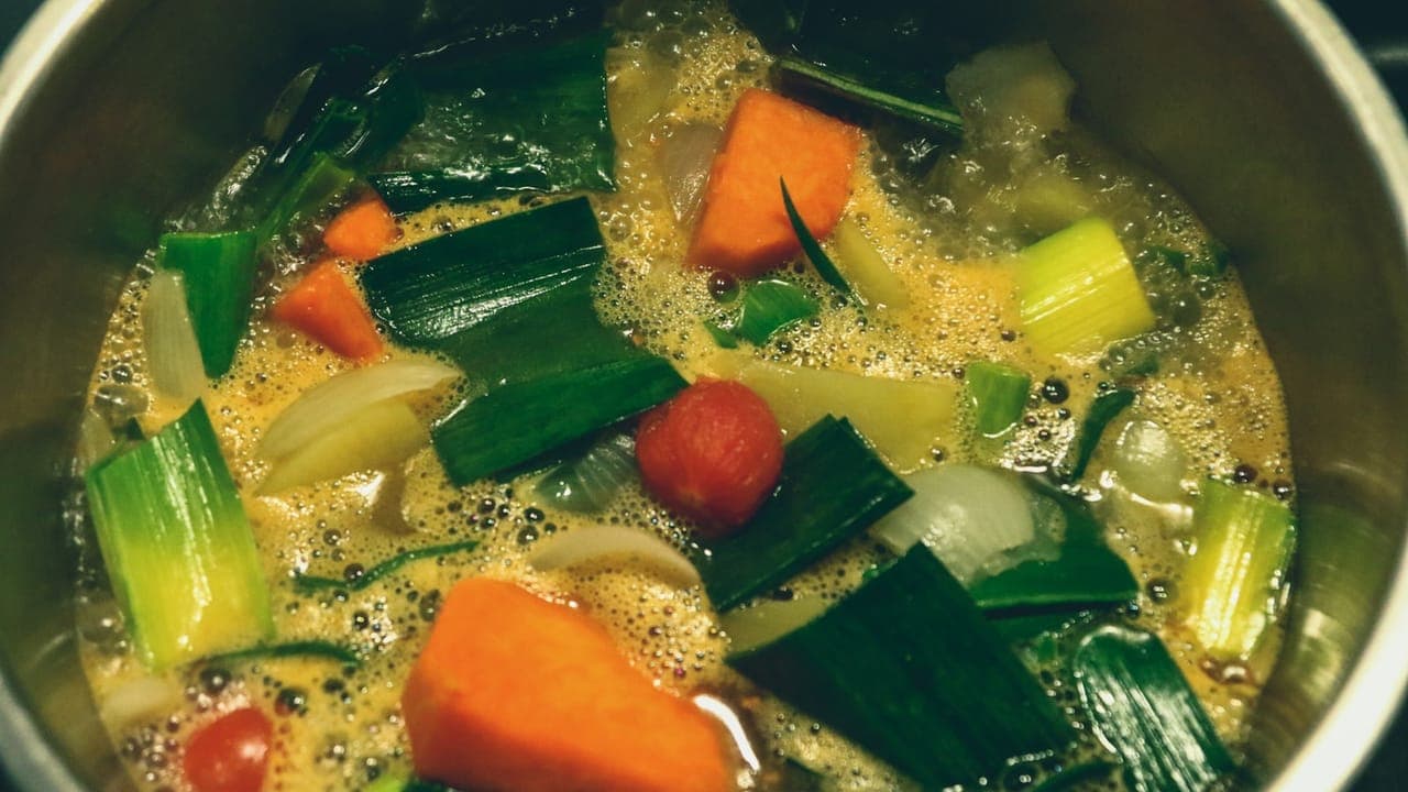 Healthy slow cooker vegetable and chicken stew in a black ceramic bowl on a wooden table