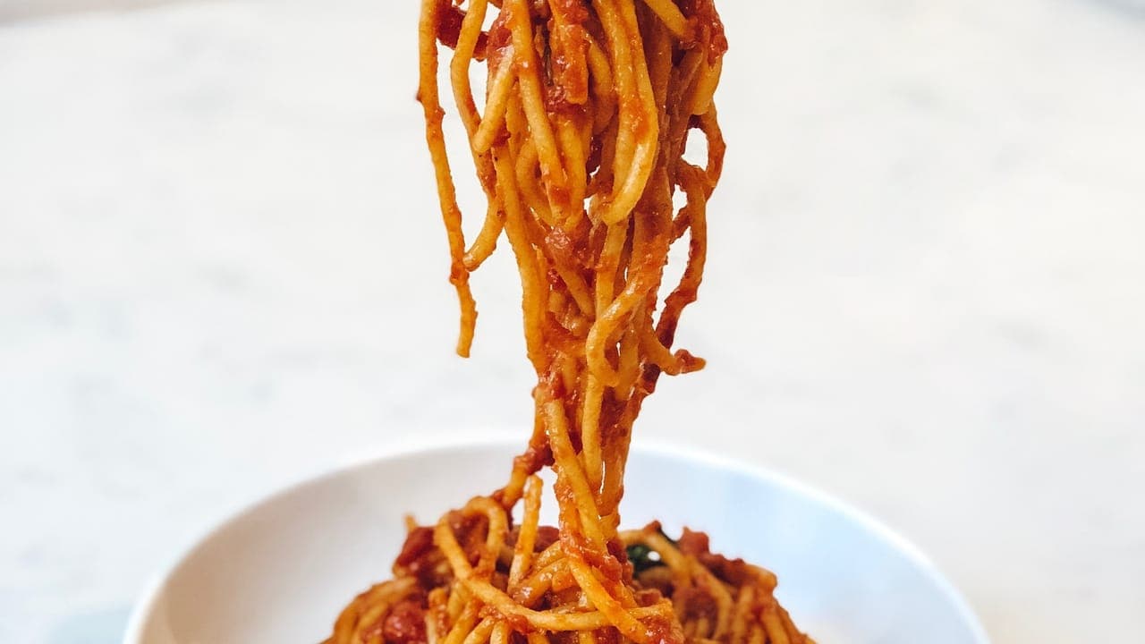 A plate of spaghetti aglio e olio tossed in garlic olive oil and topped with parsley and red pepper flakes