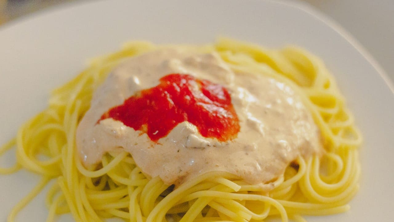Creamy Tuscan chicken pasta in a skillet with sun-dried tomatoes, spinach, and parmesan cream sauce
