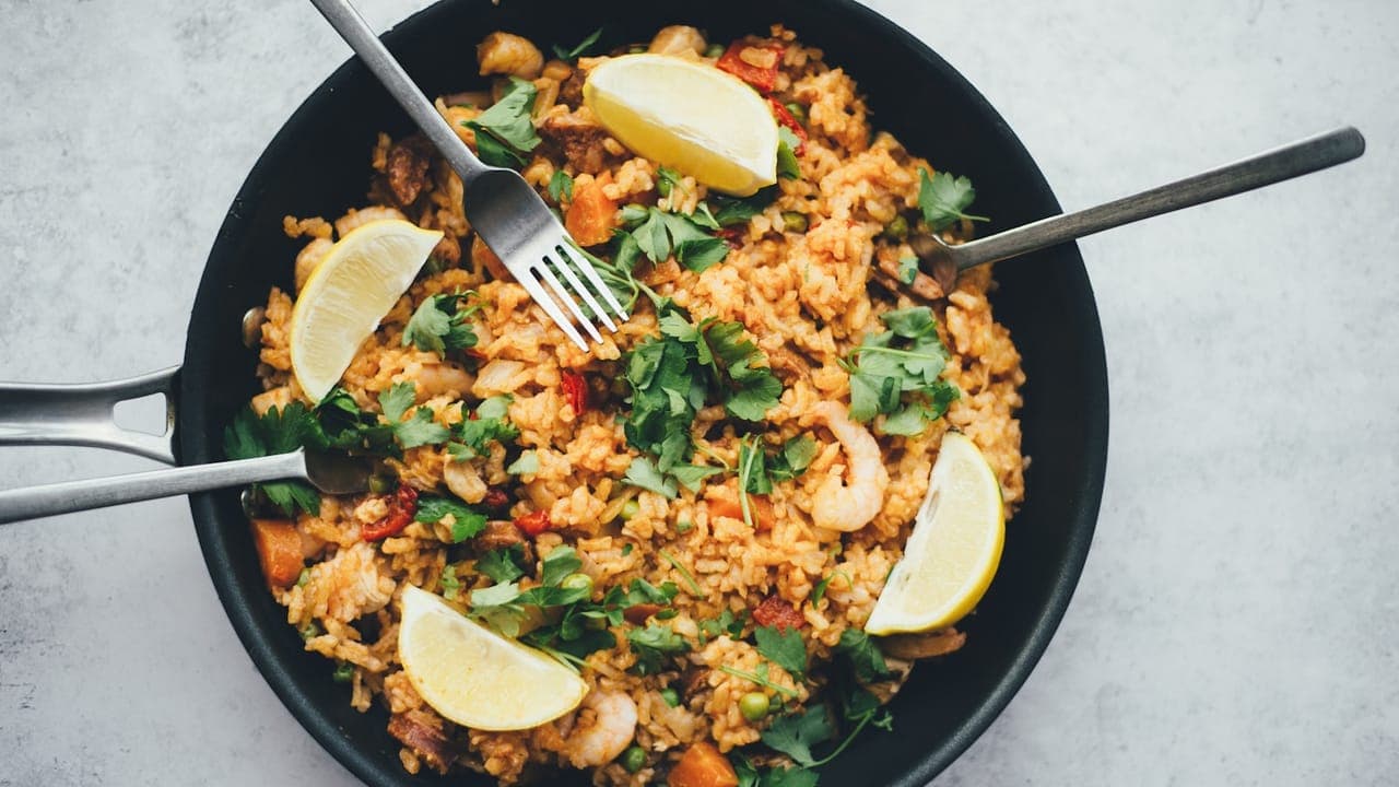 A bowl of breakfast egg fried rice with scrambled eggs, green onions, and colorful vegetables