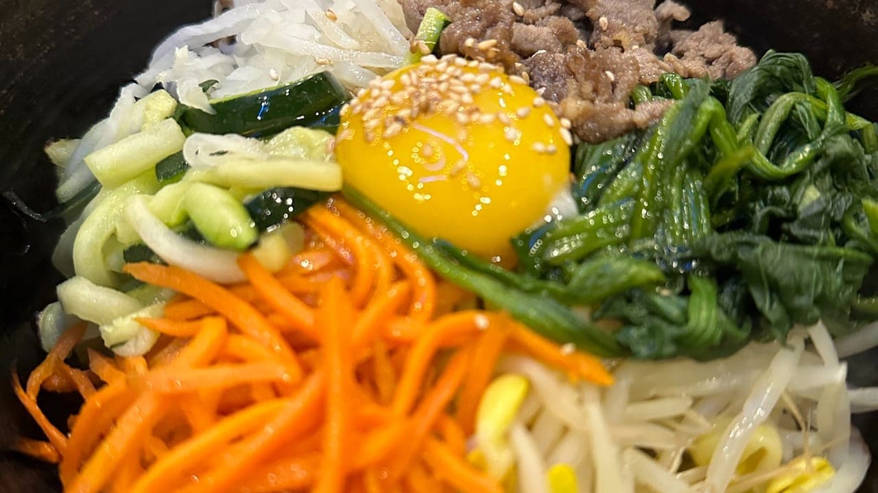 Korean ground beef bowl served over white rice topped with green onions and sesame seeds