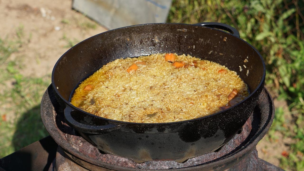 Crispy chicken thighs on a bed of garlic butter rice in a cast iron skillet