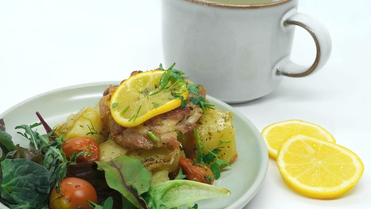 Roasted lemon herb chicken thighs with broccoli and baby potatoes on a sheet pan