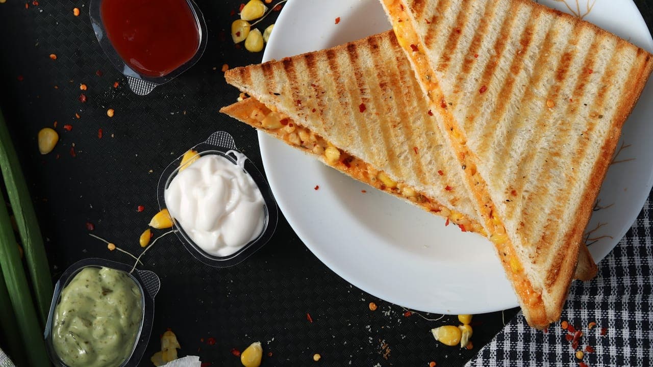 Golden toasted tuna melt sandwich cut in half showing melted cheese and creamy tuna filling
