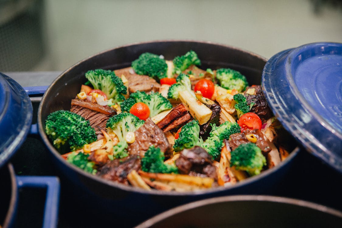 Beef and broccoli stir fry cooking in a pan with bright green broccoli florets and seared beef